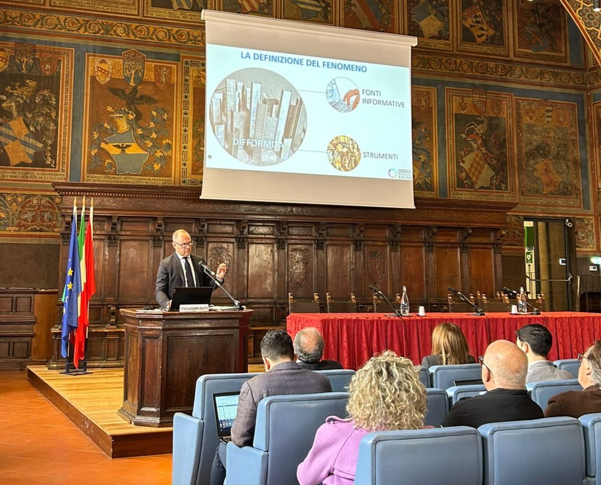 img title Uomo in completo (Nicastro) presenta una slide con diagrammi e la dicitura