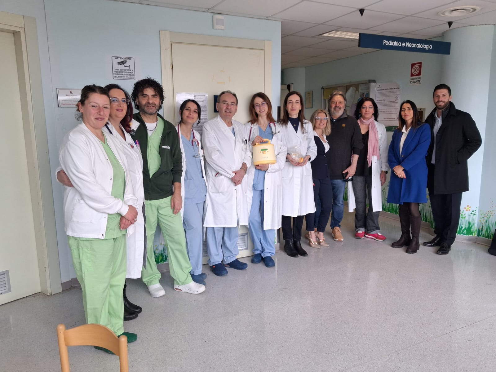 Il personale sanitario del reparto di Pediatria e i rappresentanti dell'associazione A&S posano insieme nel corridoio dell'ospedale di Città di Castello.